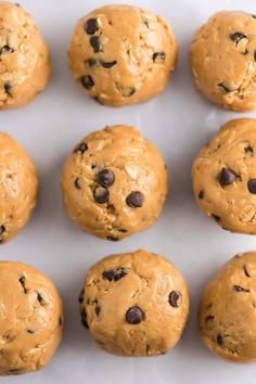 twelve chocolate chip cookies arranged in rows on a white surface with one cookie missing the middle