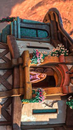 a wooden structure with flowers on the outside