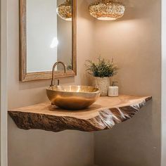 a bathroom sink sitting under a mirror on top of a wooden counter next to a vase with flowers