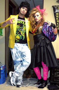 two people dressed up in costumes standing next to each other and posing for the camera