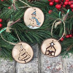 three wooden christmas ornaments hanging from a tree