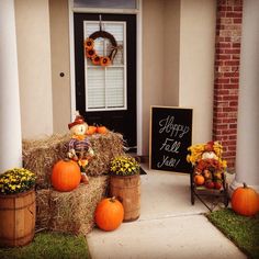 pumpkins and hay bales are sitting on the front porch with decorations around them