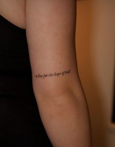 a woman with a tattoo on her arm that says, to live for the biggest effort