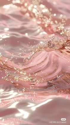 the water is pink and shiny with some gold flecks on it's surface