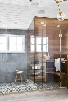 a bathroom with a glass shower door and wooden floors