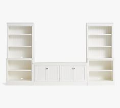 white bookcases with doors and drawers against a wall