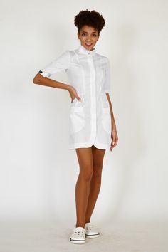 This fashionable scrub dress will make any nurse or a beautician look stylish and classy when at work. The nurse scrub dress has a provocative short length and short sleeves. The silhouette is fitted with short sleeves and roomy patch pockets. The lab coat has a stand collar and hidden snap closing. The mini length and vertical sewing tucks elongate the silhouette and make it look more elegant and slender. The fabric is 70% cotton, 30% polyester, made in the Netherlands. Your customers will get Stretch Dress With Pockets And Short Sleeves, Esthetician Uniform, Best Dress Websites, Nurse Scrub Dress, Formal Dresses Halter Neck, Scrub Dress, Repurpose Wedding Dress, White High Low Dress, Nurse Dress