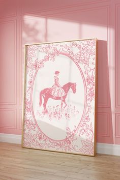 a pink and white photo frame sitting on top of a hard wood floor next to a pink wall