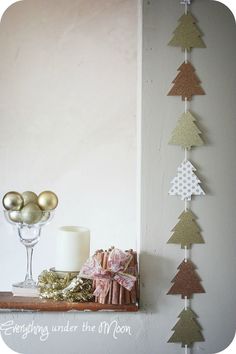 a shelf with ornaments and candles on it in front of a wall hanging from the ceiling