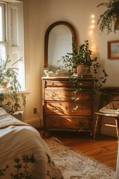 a bedroom with a dresser, mirror and plants on the wall in front of it