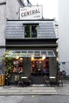 the front of a building with tables and chairs outside