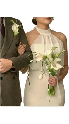 a man and woman standing next to each other with flowers in their lapel covers