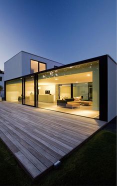 a modern house with wooden decking and sliding glass doors