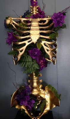 a golden skeleton with purple flowers on it