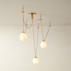 three light fixtures hanging from the ceiling in a room with white walls and flooring