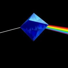 a blue diamond with a rainbow light coming out of it's side in the dark