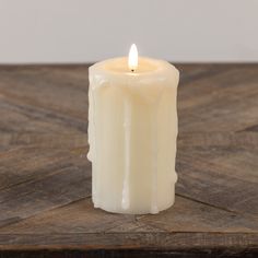 a white candle sitting on top of a wooden table