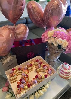 a table topped with heart shaped cakes and balloons