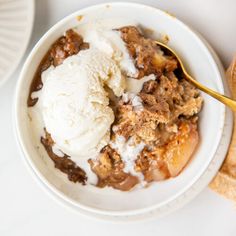 a white bowl filled with ice cream next to bread on top of a marble counter