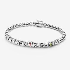 Wear a reminder of your favourites from Hawkins everywhere you go with our Stranger Things Friends Don't Lie Bracelet. Cube-shaped metal beads are individually engraved with handwritten letters that read "FRIENDS DON’T LIE". These words are separated by glitching heart and lightning bolt symbols, finished with glow-in-the-dark enamel. The rest of the bracelet is made up of round metal beads that lead to a tube-shaped clasp engraved with the Netflix logo and the initials "ST". Wear it in tribute Stranger Things Friends, Netflix Logo, Bracelet Friends, Charms Disney, Pandora Essence, Bracelet Tennis, Handwritten Letters, Lightning Bolt, Metal Beads