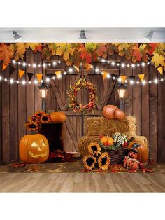 pumpkins, hay bales and lights in front of a wooden wall with autumn decorations