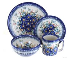 a blue and white dinner set with flowers on it