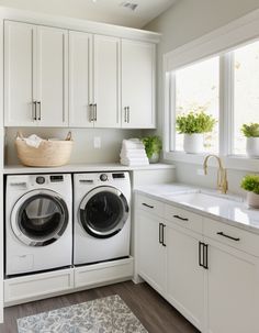 a washer and dryer in a white laundry room with lots of cabinet space