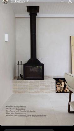 a white room with a fireplace and some logs on the floor in front of it