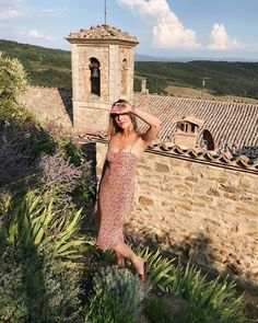 a woman standing on top of a stone building