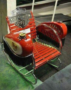 an old fashioned fire engine is sitting on the ground next to a chair with wheels