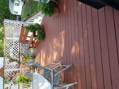 an outdoor deck with chairs and potted plants