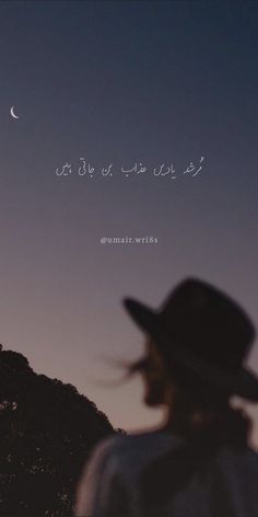 a woman wearing a hat looking at the moon in the sky with arabic writing on it