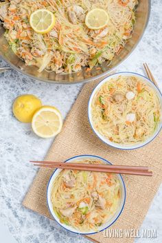 two bowls filled with food next to lemons and chopsticks