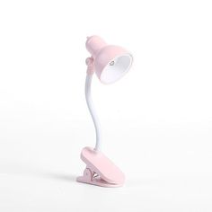 a pink and white desk lamp on a white background