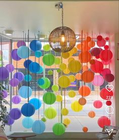 colorful paper lanterns hanging from the ceiling in front of a window