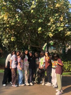 a group of people standing in front of a tree