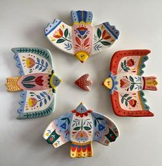 four colorful ceramic birds sitting on top of each other