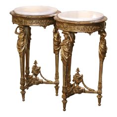 two golden tables with white marble tops on each side and an ornate design at the top