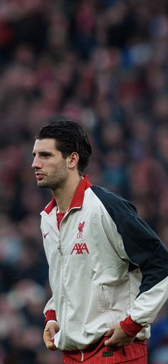 a man standing in front of a crowd wearing a white and red jacket with black sleeves