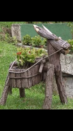 an old wooden horse planter with plants in it