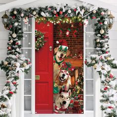 two dogs wearing christmas costumes standing in front of a red door