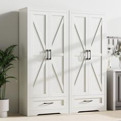 a white cabinet with two doors and drawers in a room next to a potted plant