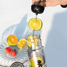 a person is squeezing lemons into a glass with a straw in front of them