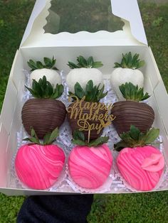 four chocolate covered strawberries in a box with happy mother's day written on them