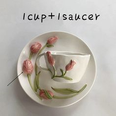 a white plate with pink flowers on it and the words i cupti saucer