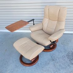 a reclining chair and ottoman in front of a garage door with a wooden table