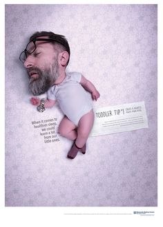 a man laying on top of a baby in a diaper with a tag around his neck