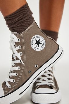 a woman's legs wearing brown converse sneakers