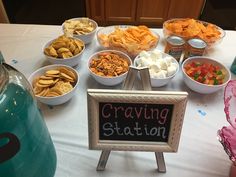 a table topped with bowls filled with food next to a chalkboard that says crawling station