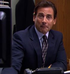 a man in a suit and tie sitting at a desk